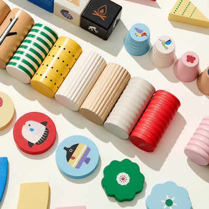 Top-down view of solid beech wood blocks in various shapes, patterns, and colors arranged neatly on a white surface