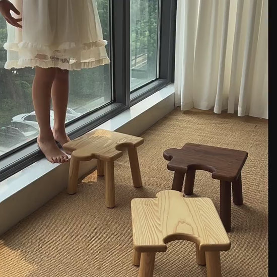 Solid wood kids puzzle stool with an interlocking design, shown as a step stool and seat with a smooth finish, sturdy construction, and playful shape for everyday use.