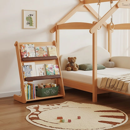 Montessori bookshelf side filled with picture books next to a wooden house-shaped floor bed frame