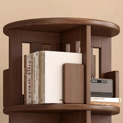 Close-up of the top shelf of a dark solid rubberwood rotating bookshelf holding books and a small radio