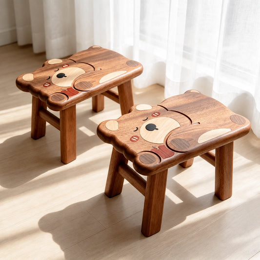 Two solid ebony wood sleeping bear toddler stools placed together near a window