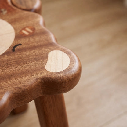 Close-up of the smooth rounded corner edge on the solid ebony wood toddler stool seat