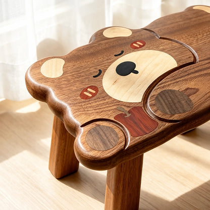 Close-up of the sleeping bear face inlay detail and natural wood grain on the toddler stool seat
