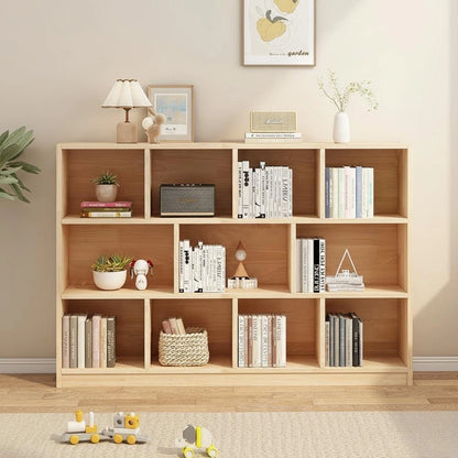 Front view of a three-tier solid pine staggered cubby bookshelf holding books and decorative items