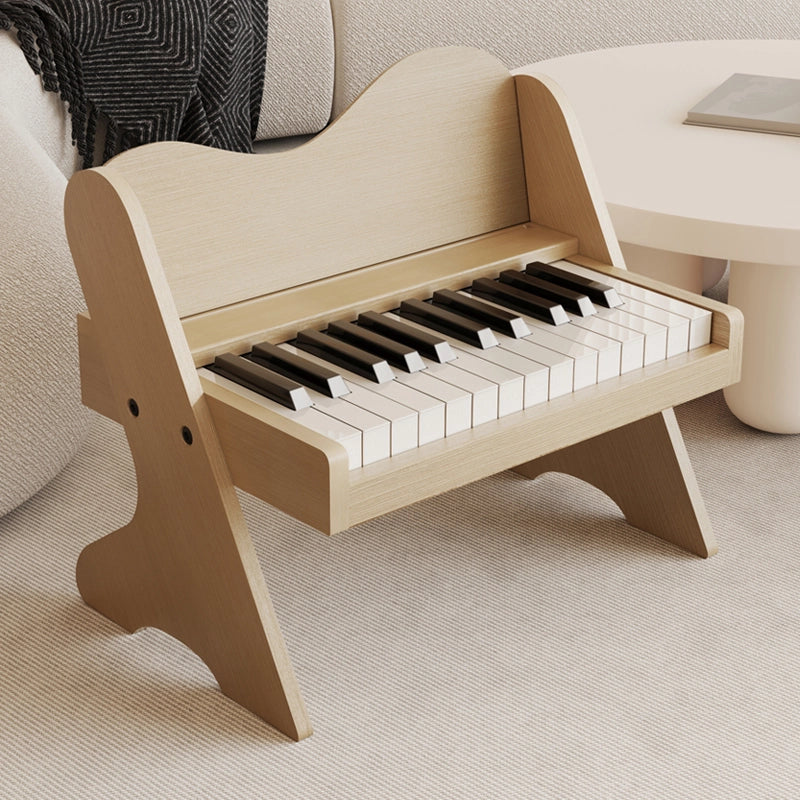 Three-quarter view of a plywood toddler electronic piano with a light natural wood finish on a rug