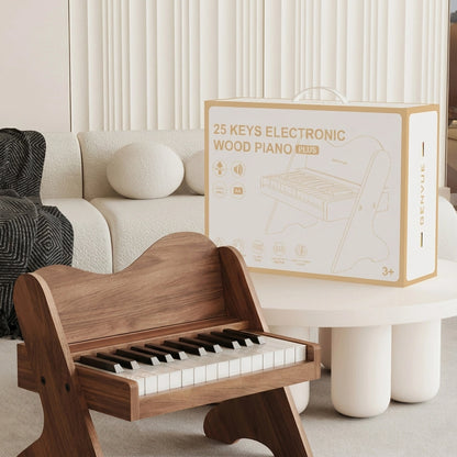 Walnut-finish plywood toddler electronic piano with its white retail product box on a table