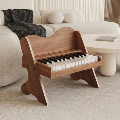 Three-quarter view of a plywood toddler electronic piano with a dark walnut finish on a rug