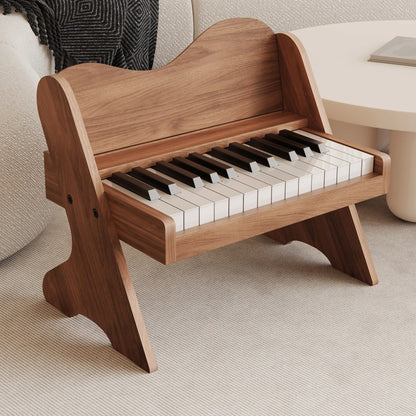 Three-quarter view of a plywood toddler electronic piano with a dark walnut wood finish on a rug