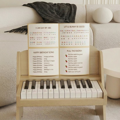 Front view of a light wood plywood toddler electronic piano holding an open song booklet
