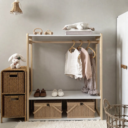 Front view of a toddler garment rack and wardrobe filled with children clothes and storage baskets