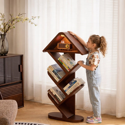 Little girl standing next to a solid rubber wood tree shape floor bookshelf filled with books