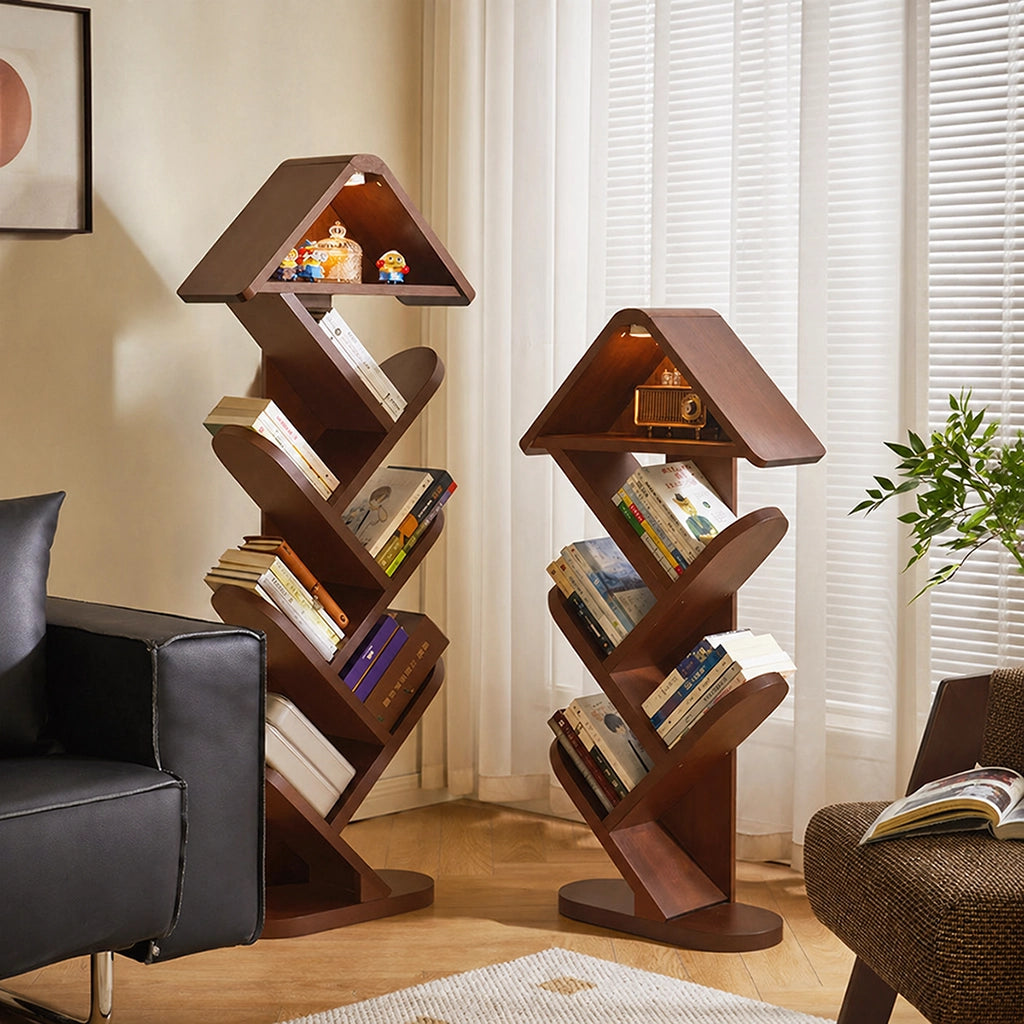 Two solid rubber wood tree shape bookshelves standing next to a black leather chair near a window
