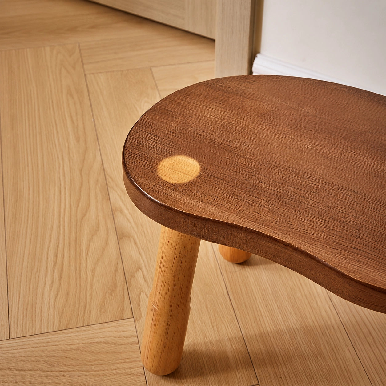 Close-up of the two-tone wood grain seat surface showing a round light-colored inlay detail