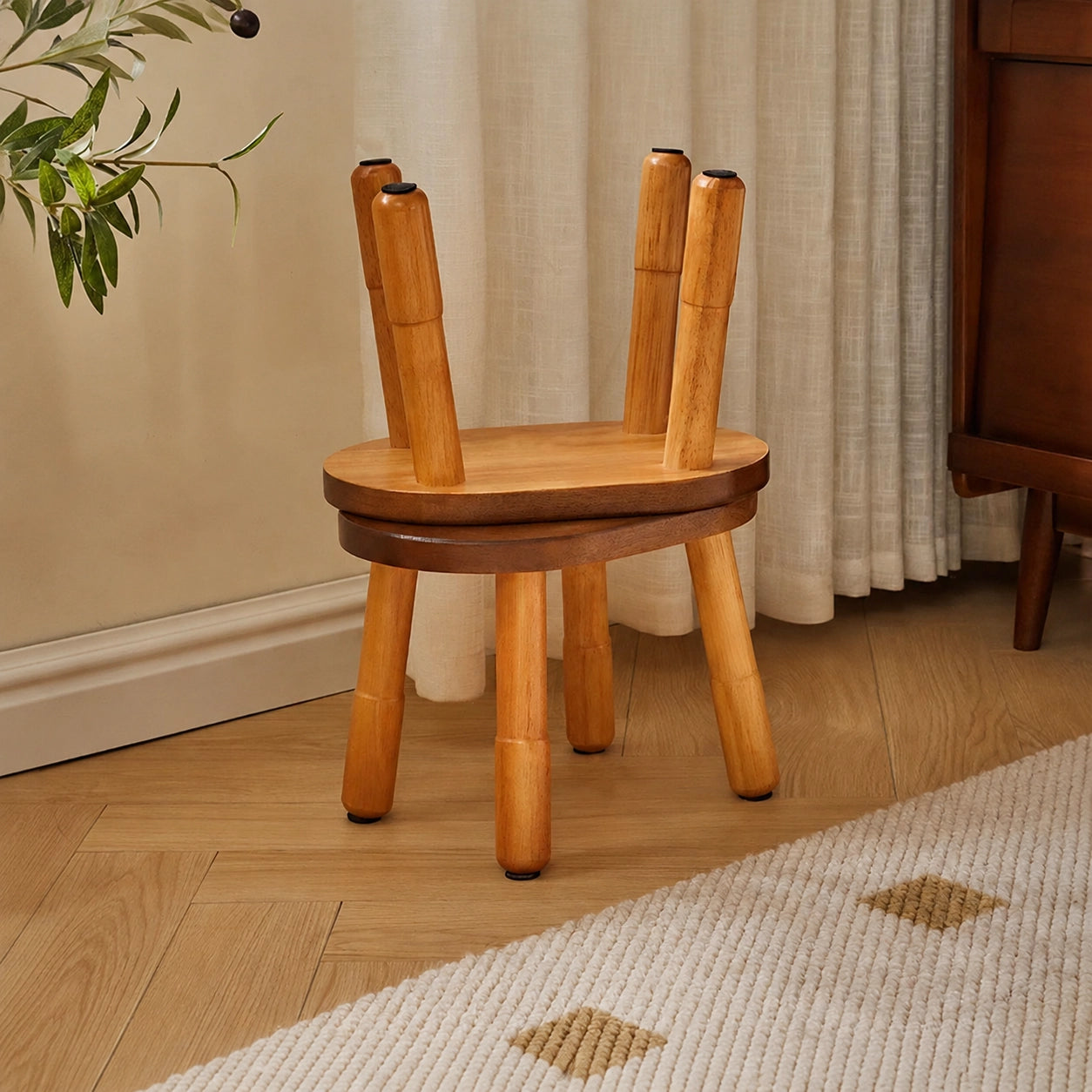 Two solid rubber wood low stools stacked together with one placed upside down on top of the other