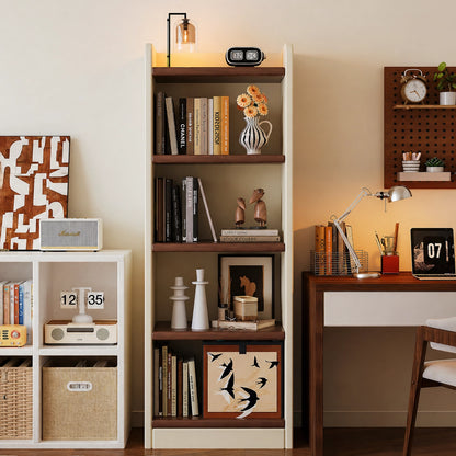 Two-tone floor bookshelf styled next to a wooden writing desk and laptop in a home office setting