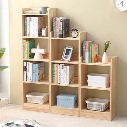 Three-quarter view of modular solid pine bookcases showing tiered storage shelves with books and a small clock